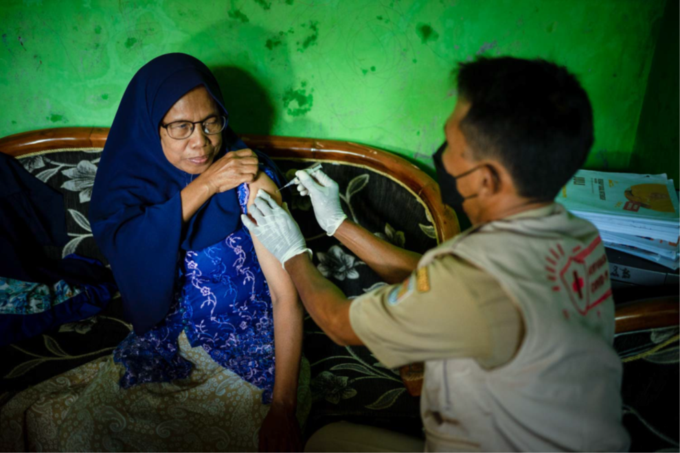 Asringatinah (a person with disability), received the vaccine from a team of volunteers at her home in Ujung Gagak Village. Photo: AIHSP